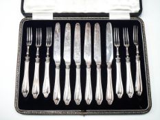 A set of six silver handled tea knives and forks, the shaped handles with floret terminals,