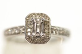 A 9 carat white gold ring set with single cut diamonds around a step cut cubic zirconia,