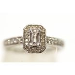 A 9 carat white gold ring set with single cut diamonds around a step cut cubic zirconia,