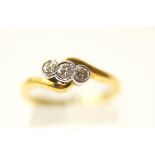 A three stone diamond 18 carat gold crossover ring,