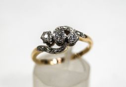 A diamond three stone cross-over ring, the round brilliants approximately 0.