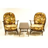 A pair of Ercol Windsor stick back armchairs, with floral patterned cushions,