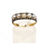 A late Victorian graduated pearl five stone carved half-hoop ring with rose diamon points,