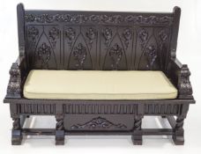 A 20th Century stained carved oak hall bench, with applied scroll mounts,
