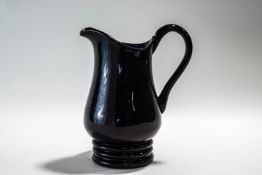 An early 20th Century amethyst glass jug,