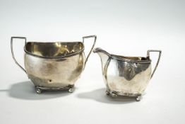 A late Victorian silver oblong cream jug and matching sugar, with angular handles,