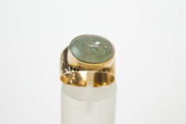 A Jade ring, the mount stamped '9ct', the cabochon, approximately 1.4 cm by 1 cm, finger size M, 4.