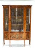 An Edwardian satinwood display cabinet, of serpentine form,