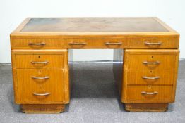 A 1950's oak pedestal desk, with tooled leather writing surface,