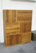 A 1970's Heals oak veneered wall unit, comprising five cupboards of varying sizes and three drawers,