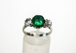 A three stone emerald and diamond ring, stamped 'Platinum',