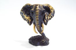 A modern bronze sculpture of an elephant's head, signed MILO,