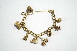 A 9 carat gold bracelet, of curb links, to a padlock clasp, with seven charms attached, 28.