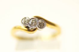 A three stone diamond 18 carat gold crossover ring,