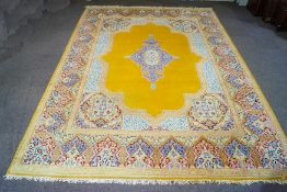 A modern machine made Persian carpet, with central medallion over a mustard yellow ground,