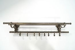 A nickel brass hanging rack with sliding hooks,