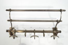 A nickel on brass hanging rack, with sliding hooks,