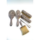 A late Victorian silver four piece dressing table set, comprising a hand mirror, two hair brushes,