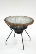 A wicker framed coffee table with metal supports and glass top, 64cm diameter,