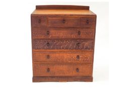 A 1930s oak chest of three short over four long drawers, on a stepped plinth base,