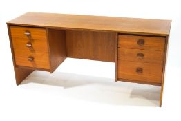 A Stag teak desk with six drawers, 151cm wide x 43.