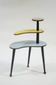 A 1950's metamorphic three tier plant stand, with three rod and ball legs and formica top,