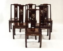 An Oriental hardwood extending dining table and six chairs,