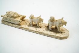 An Inuit carved bone model of a sledge and two dogs,