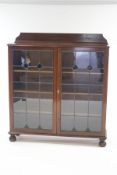 A 20th Century mahogany glazed bookcase, the doors inset with stained glass,