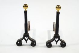 A pair of cast iron fire dogs with brass ball finials, 56.