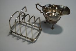 A silver cream jug, by Williams (Birmingham) Ltd, Birmingham 1907, of helmet shape on three suppors,