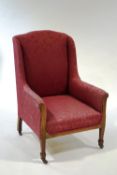 An early 20th Century wing armchair with oak frame,