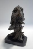 A modern bronze head of an eagle, signed Milo, on a black marble base,