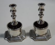 A pair of silver plated taper sticks, on shaped square bases, 11.