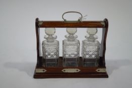 An oak three decanter tantalus,