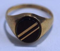 A 9 carat gold signet ring, set with an oval onyx having diagonal gold bands, finger size Q, 2.