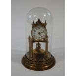 A late Victorian brass tortion clock with enamel dial, under a glass dome,