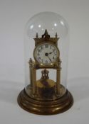 A late Victorian brass tortion clock with enamel dial, under a glass dome,
