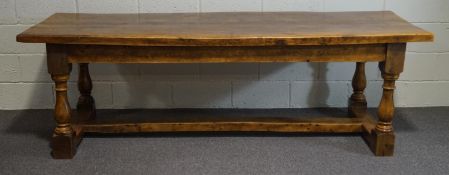 A 20th Century oak refectory table, the turned baluster legs united by a plank stretcher,