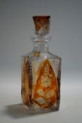 A Bohemian style cut glass decanter and stopper, arched amber coloured panels with flower designs,