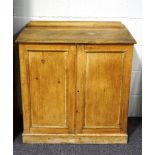 A pine two door cupboard with raised back and plinth base,