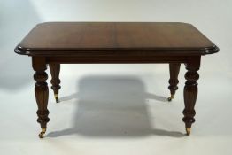 A reproduction mahogany wind-out dining table in the Victorian style, with two additional leaves,