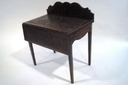 An early 19th Century oak Pembroke table with later carving