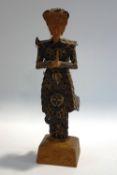 A Chinese coin figure of Princess Fu Hao, on a wooden base,