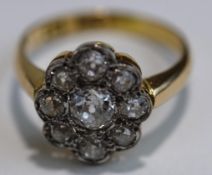 A nine stone diamond cluster ring, stamped '18ct', the old brilliant cuts totalling approximately 1.