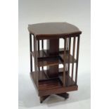 A Edwardian mahogany revolving bookcase with satinwood stringing and shaped top,