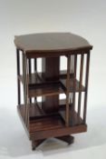 A Edwardian mahogany revolving bookcase with satinwood stringing and shaped top,