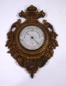 A Negretti & Zambra wall barometer, the oak frame heavily carved with fruit and scrolls,