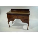 A mid 20th Century mahogany desk with leather inset top,