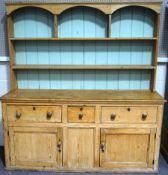 A Victorian pine kitchen dresser, the rack with three arched shelf sections,